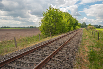 Picturesque landscape with diagonal rusty single track rails