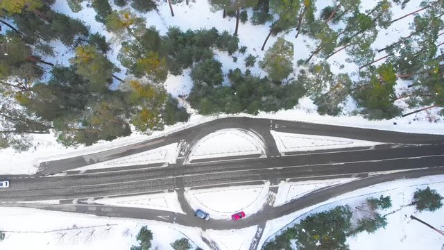 Vista a&eacute;rea del bosque y la carretera pasando coches en invierno. Los &aacute;rboles est&aacute;n cubiertos de nieve / Aerial view of the forest and the road passing cars in winter. Trees are covered in snow