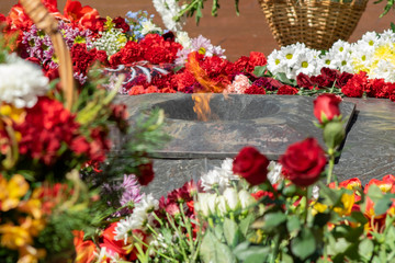 flowers lie at the eternal flame at the memorial to the victims and fallen soldiers