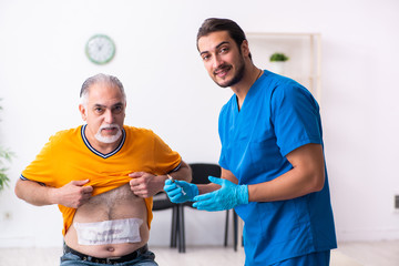 Obraz premium Old man visiting young male doctor