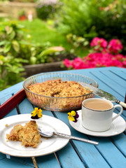 Close-up view on coffee with a rhubarb crumble in garden