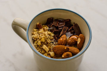 Oat porridge in cup for breakfast, on light colored table. Healthy eating, healthy food for breakfast