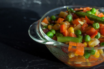 steamed vegetables on plate at dark background
