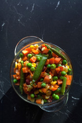 steamed vegetables on plate at dark background