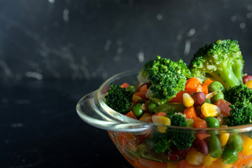 steamed vegetables on plate at dark background