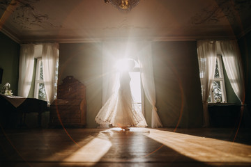photo of a bride dancing in the light at the window