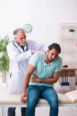 Injured young man visiting old doctor