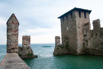 Fototapeta premium view of Sirmione Castle on Lake Garda with a boat in the background