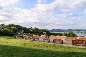 Tihany, Hungary - May 10, 2020: View from Tihany at sunset, with benches and people in the...