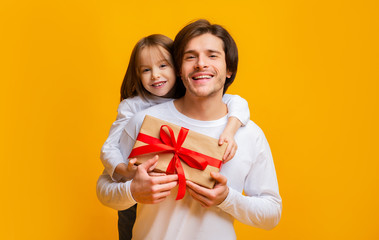Little daughter and father holding gift box