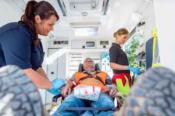 Emergency doctor in ambulance talking to injured man © Kzenon
