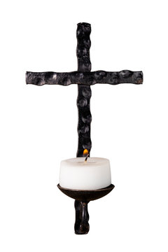 Ein schwarzes Eisenkreuz mit einer brennenden Kerze.