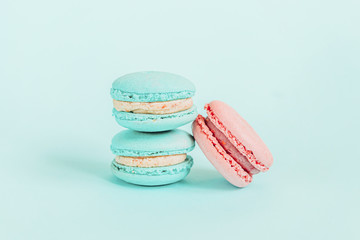 Sweet almond colorful unicorn blue pink macaron or macaroon dessert cake isolated on trendy blue pastel background. French sweet cookie. Minimal food bakery concept Copy space