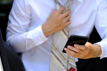 businessman working with laptop computer and using his phone outdoors