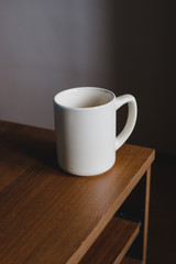white ceramic mug on a wooden table.