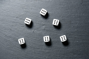 Black stone blackboard with playing dice on