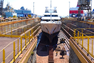 Photo of ship repairs of yacht in hull in shipyard floating dry dock