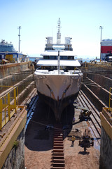Photo of ship repairs of yacht in hull in shipyard floating dry dock