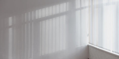 light through large window illuminate white wall in empty room
