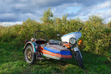 Fototapeta na wymiar Old Soviet retro motorcycle with sidecar IZH Planeta