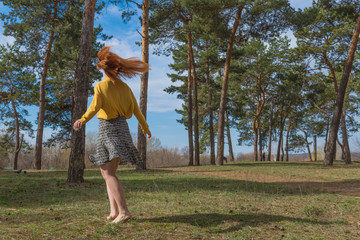 beautiful girl enjoying the spring sun in forest on a warm day.