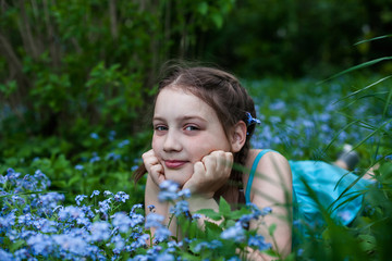 beautiful girl  lying in forget me not flowers
