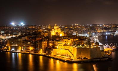 Fototapeta na wymiar Night view of old architects in Senglea area viewed from Valletta city Malta.