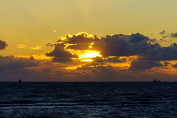 Golden sunset with deep blue ocean and cargo ships in Oresund, Hittarp, Sweden.