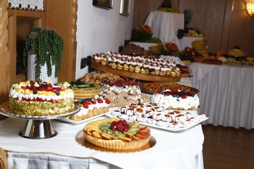 buffet with sweets. fruits and other sweets on dessert table. Rows of tasty looking desserts in beautiful arrangements. Sweets on banquet table - picture taken during catering event
