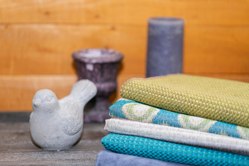 Fabrics with ceramic vases and a wooden box with dried flowers on a wooden background