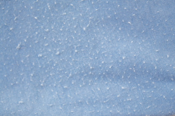  Blue clothes in spools on white background close-up with copy space. Problem of poor quality clothing and quick wear