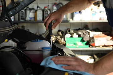 Professional auto mechanic fixing modern car in service center, closeup