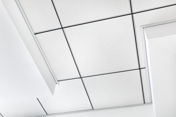 multi level ceiling pattern with three dimensional protrusions and a suspended tiled ceiling white...