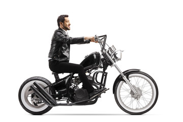 Obraz na płótnie Canvas Young man in leather jacket riding a chopper motorbike