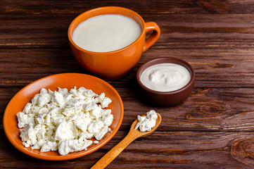 Homemade dairy products - kefir, cottage cheese, sour cream on a wooden background, copy space, flat lay.