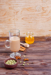 Traditional Indian tea Masala tea in a tall glass cup. Ingredients for making tea.