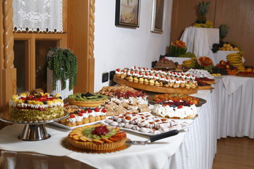 buffet with sweets. fruits and other sweets on dessert table. Rows of tasty looking desserts in beautiful arrangements. Sweets on banquet table - picture taken during catering event