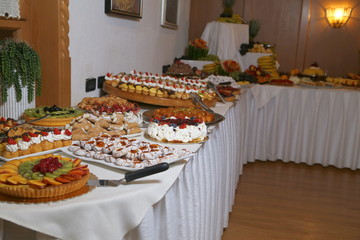 buffet with sweets. fruits and other sweets on dessert table. Rows of tasty looking desserts in beautiful arrangements. Sweets on banquet table - picture taken during catering event