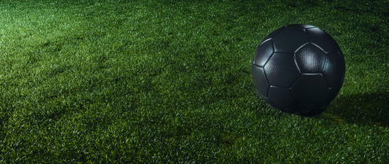 Black football on an illuminated sports field at night