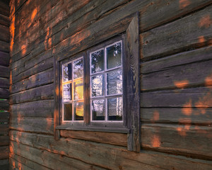 Window of an old country house illuminated by the rays of the evening sun