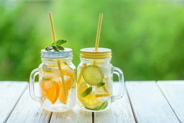 Two cans of lemonade on a natural green background