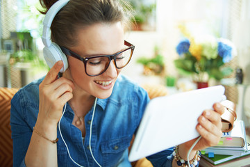 smiling woman with white headphones and tablet PC study online