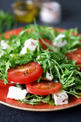 Selective focus. Macro. Salad with arugula, tomato and feta cheese. Nutritious super salad. Keto diet. Keto lunch.