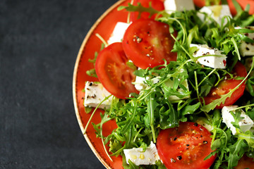 Selective focus. Macro. Salad with arugula, tomato and feta cheese. Nutritious super salad. Keto diet. Keto lunch.