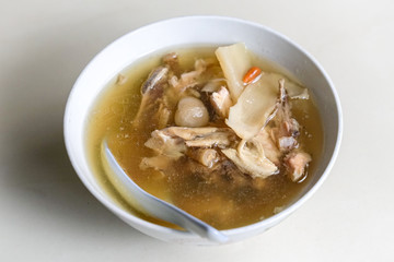 Chinese traditional american ginseng soup with chicken bones served in a bowl.