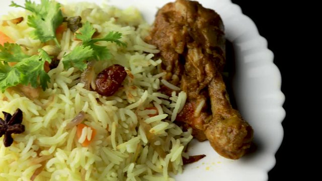 Chicken Biryani showing leg piece - It's a delicious recipe of Basmati rice mixed with with spicy marinated chicken in a bowl. Served in a bowl or plate. Selective focus	