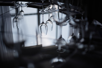 near the window on a dark background is a mirror table with dishes, reflection of glasses in the glass,