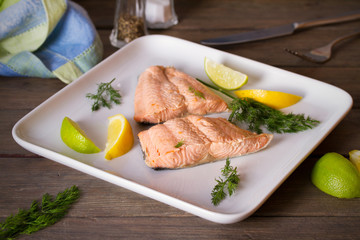 Steam cooked salmon with lemon and dill on white plate. Healthy diet detox food concept