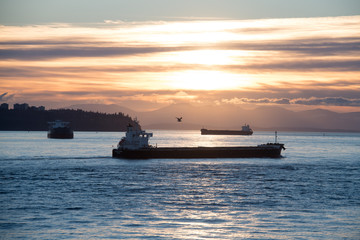 Obraz premium Tanker and Freighter Ships Wait in Burrard Inlet Vancouver, British Columbia to load and unload at the Port of Vancouver