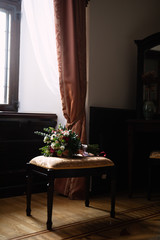 by the window there is a chair on which lies a bouquet of flowers, flowers for the bride, a wedding bouquet,